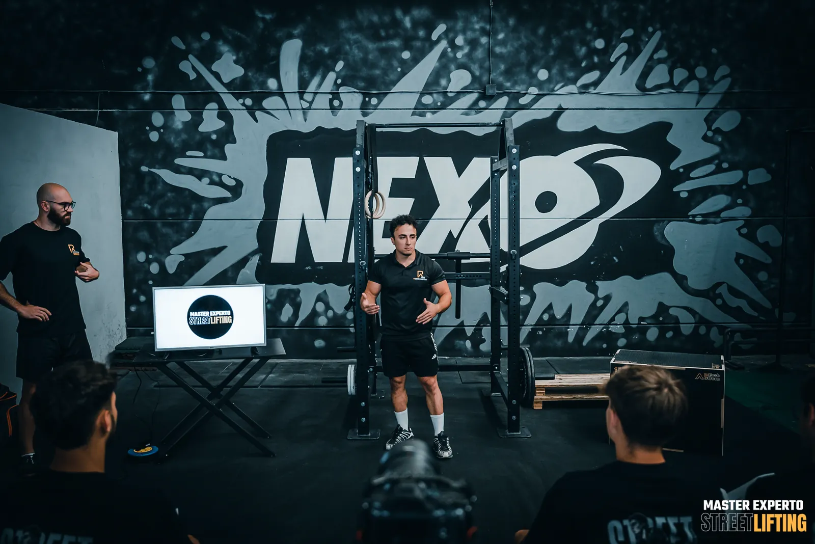 Demostración práctica frente al mural de Nexo Strength Club