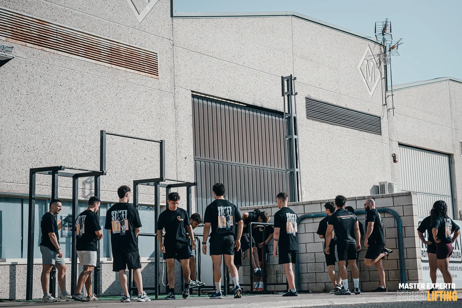 Alumnos entrenando en las barras de la calle